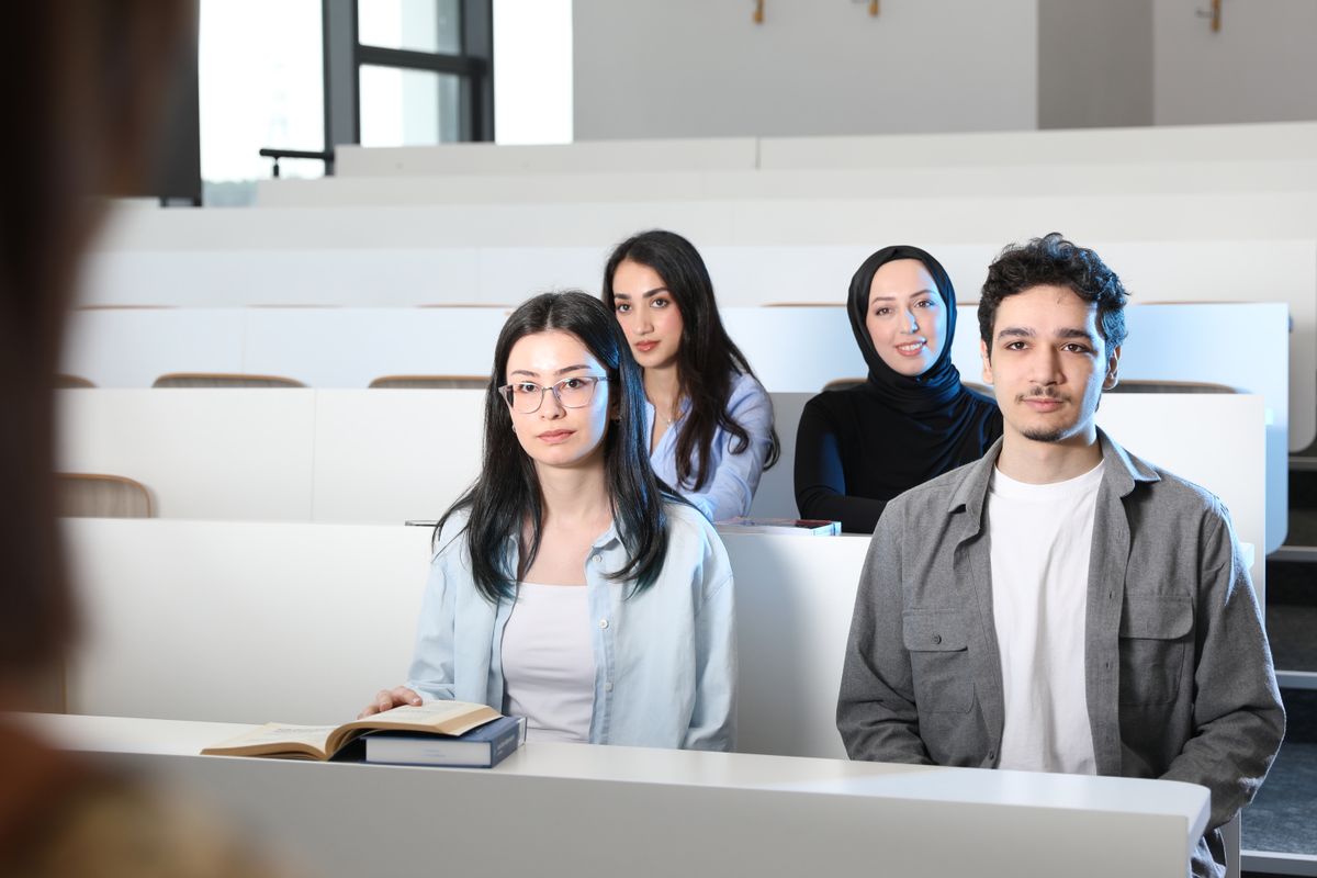 Students sharing a lecture space with notebooks and laptops
