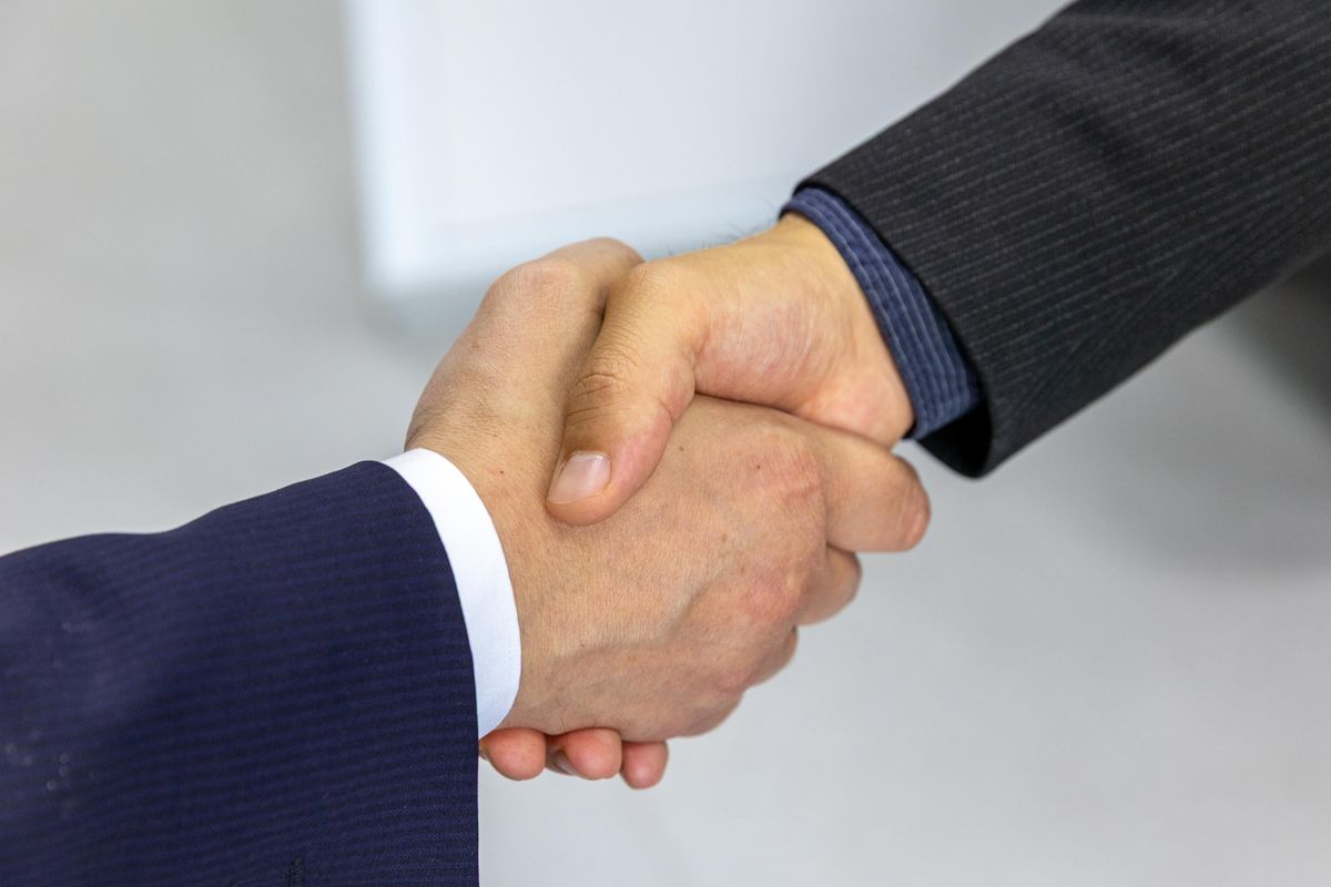 Two people shaking hands at the start of a conversation